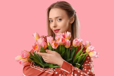 İşitme cihazı ve pembe arka planda laleleri olan genç bir kadın. Uluslararası Kadınlar Günü