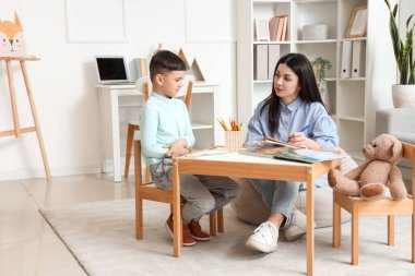 Ofiste küçük bir çocukla çalışan kadın psikolog.