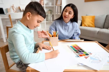 Ofisteki masada psikolog çizen küçük çocuk.