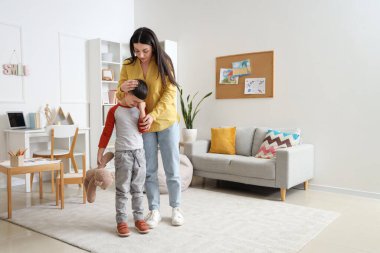 Ofiste oyuncak ayı ve psikologla ağlayan küçük çocuk.