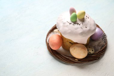 Paskalya pastası ve açık mavi arka planda boyanmış yumurtalar.