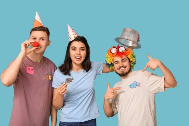 Mavi arka planda kağıt çıkartmaları olan komik kılık değiştirmiş genç arkadaşlar. 1 Nisan kutlamaları