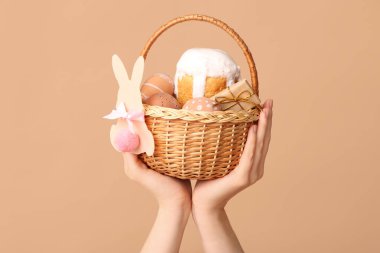 Bej arka planda Paskalya için sepet tutan kadın.