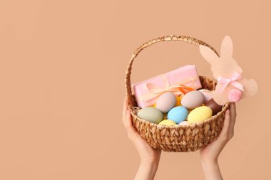 Bej arka planda Paskalya için sepet tutan kadın.