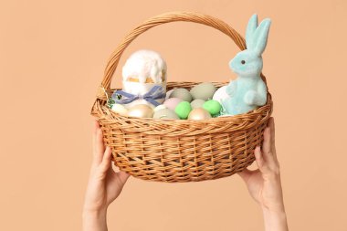 Bej arka planda Paskalya için sepet tutan kadın.