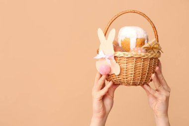 Bej arka planda Paskalya için sepet tutan kadın.