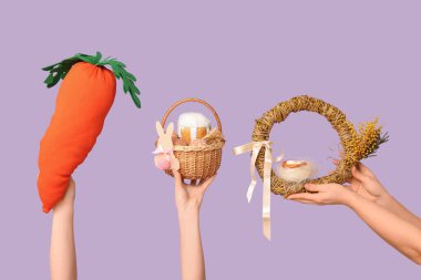 Paskalya bayramı çelengi, sepet ve arkaplanda havuç taşıyan kadın eller.