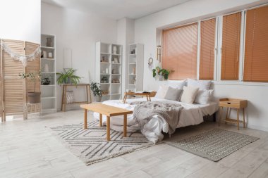 Hafif yatak odasının içinde rüzgar çanı, düş kapanı ve bitkiler var.