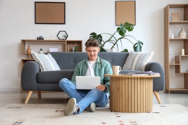 Katta evde dizüstü bilgisayar kullanan genç adam