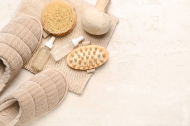 Beyaz arka planda bir çift bej yumuşak terlik ve vücut bakım malzemeleri. Üst görünüm
