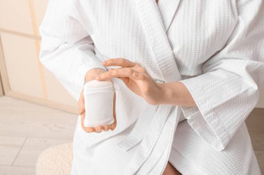 Evde deodorantı olan genç bir kadın, yakın plan.