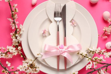 Pembe arka planda çiçek açan dalları olan Paskalya sofrası