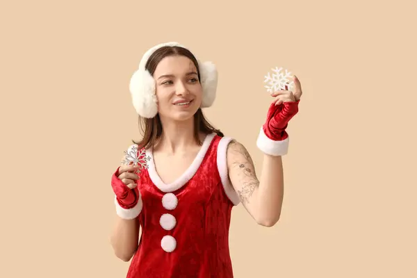 Красивая Молодая Женщина Костюме Санта Клауса Декоративными Снежинками Бежевом Фоне — стоковое фото