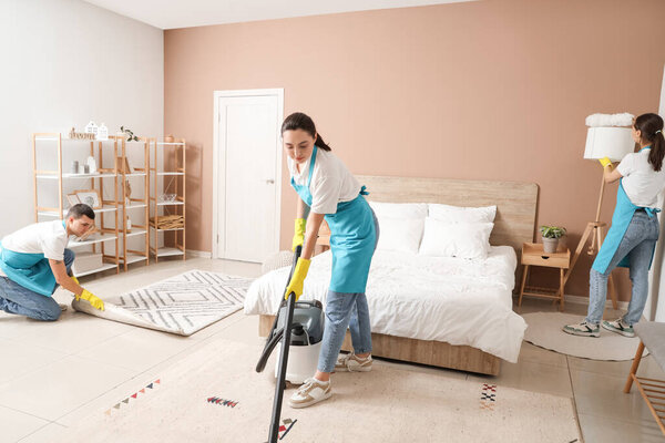 Young janitors cleaning in bedroom
