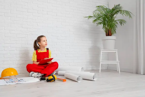Little architect with clipboard sitting in room