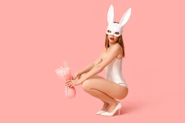 Сексуальная Молодая Женщина Маске Кролика Пасхальным Подарком Сидя Розовом Фоне — стоковое фото