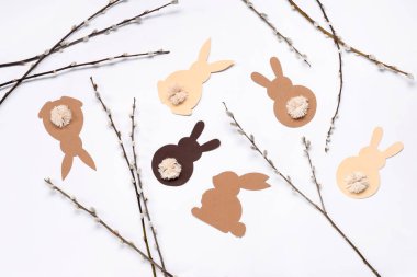 Pussy willow branches and paper bunnies on white background. Easter celebration