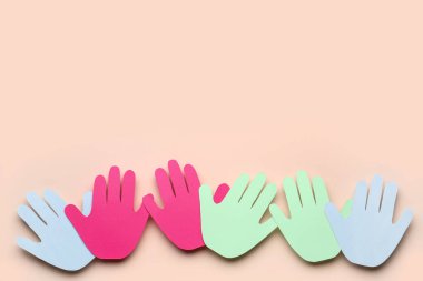 Bej arkaplanda Dostluk Günü için renkli kağıt avuç içleri