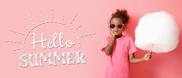 Excited little African-American girl with cotton candy and text HELLO SUMMER on pink background