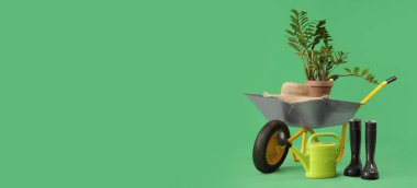 Yeşil zemin üzerinde bitki ve bahçe malzemeleri ile el arabası metin için yer ile