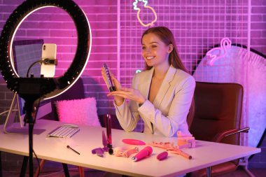 Female blogger with vibrator conducting sex education online at home