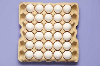 Leylak arkaplanda karton kutuda tavuk yumurtası