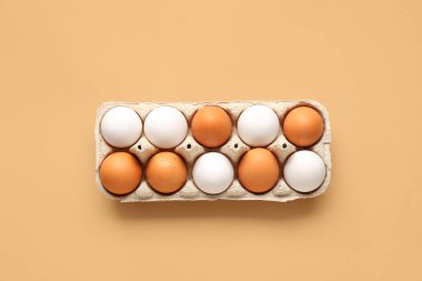 Bej arkaplanda karton kutuda yumurtalar