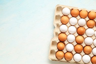 Mavi grunge arka planda karton kutuda tavuk yumurtaları