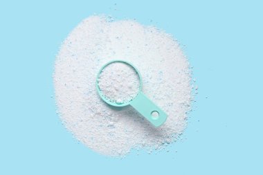 Mavi arka planda çamaşır deterjanı kepçesi