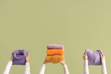 Yeşil arka planda katlanmış kazaklı kadınlar