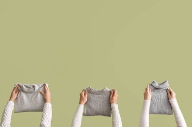 Yeşil arka planda katlanmış kazaklı kadınlar