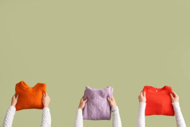 Yeşil arka planda katlanmış kazaklı kadınlar