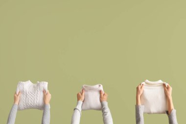 Yeşil arka planda katlanmış kazaklı kadınlar