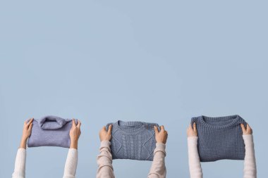 Açık arkaplanda katlanmış süveter giyen kadınlar