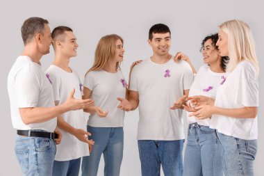 Lavanta rengi farkındalık kurdeleleri olan insanlar arka planda konuşuyor. Dünya Kanser Günü