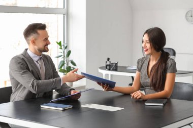 İnsan Kaynakları Müdürü, kadın başvuru sahibini ofisinde sorguluyor.