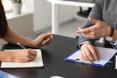 İnsan Kaynakları Yöneticisi ofis masasında başvuran kadınla görüşüyor, yakın plan.