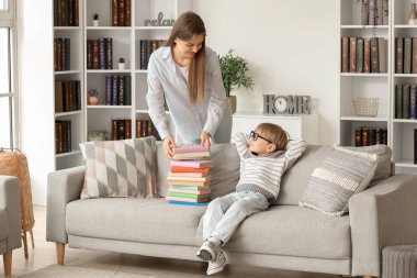 Evde farklı kitapları olan sevimli bir çocuk ve annesi.