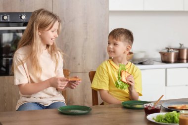 Mutfakta kadeh kaldıran küçük çocuklar.