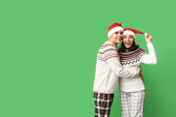 Feliz Jovem Casal Pijama Natal Abraçando Fundo Verde — Fotografia de Stock