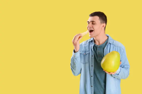 黄色い背景でポケロを食べている若い男 — ストック写真