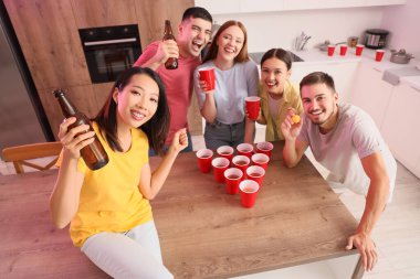 Bir grup genç arkadaş partide bira pong oynuyorlar.