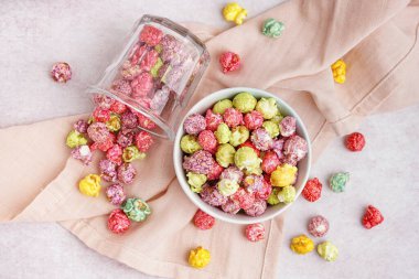 Beyaz arka planda tatlı renkli patlamış mısırlı kase ve cam.