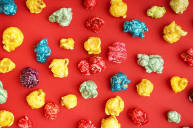 Kırmızı arka planda tatlı renkli patlamış mısır