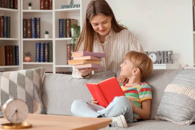Evde kitapları olan küçük bir çocuk ve annesi.