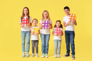 Sarı arka planda etiketleri olan bir grup sevimli çocuk.