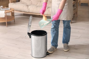 Oturma odasındaki çöp kutusuna çöp atan adam, yakın çekim.