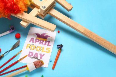 Yazılı APRIL FOOLS Day kartı, sanatçı araçları ve renk arkaplan üzerinde parti ıslıkları