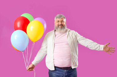 Pembe arka planda renkli balonları olan son sınıf öğrencisi.