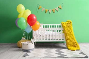 İçinde renkli balonlar ve beşik olan çocuk odasının içi.